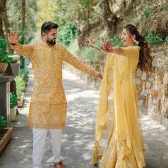 A fun, candid moment from a Haldi ceremony, with the couple sharing a dance in a beautiful outdoor setting. Their coordinated yellow outfits and joyful expressions say it all.