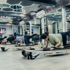 The energy in our group Reformer classes is motivating. Here, clients are synchronized in a leg and core exercise, building strength together while maintaining individual focus and form.