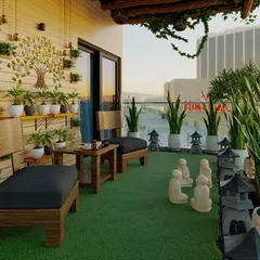 Another view of a zen-inspired seating area. The design uses natural wood furniture, a vertical 'tree of life' wall planter, and serene Buddha statues to create a calming and spiritually uplifting atmosphere.