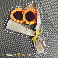 A rustic and charming sunflower bouquet wrapped in newspaper-print paper with a simple yellow ribbon. This arrangement gives off a lovely, vintage vibe.