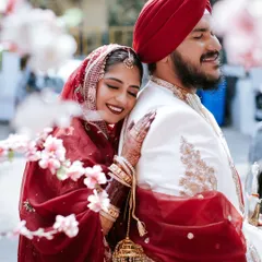 Love that feels like home. This candid shot from a Sikh wedding captures the bride resting her head on her groom's shoulder, a quiet moment of peace and affection amidst the Anand Karaj ceremony preparations.
