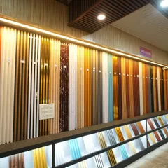 A close-up of our illuminated display wall for fluted panels. The light from below highlights the texture and true color of each design, from dark wood to metallic finishes.