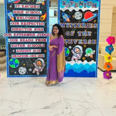 Posing next to the beautifully decorated welcome boards at St. Xavier's High School. The theme for the event was 'Mysteries of the Universe,' and the students' creativity was out of this world.