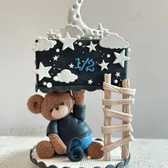 Part of our "Gullu" family, this gravity-defying cake is for a half-birthday celebration. A cute teddy bear holds up a night-sky-themed cake, complete with a fondant moon, stars, and a little ladder.