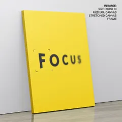 A bold and bright motivational print with the word "FOCUS." Shown here as a stretched canvas, its minimalist design and vibrant yellow background serve as a powerful daily reminder in a home office or creative space.