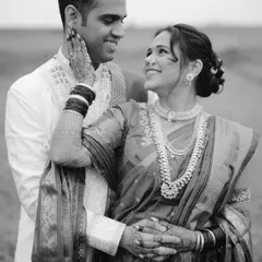 An intimate black and white portrait that feels timeless. The focus is entirely on the couple's loving gaze and gentle touch.