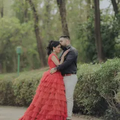 A classic portrait from an engagement shoot in a lush Pune garden. The woman's striking red gown and the couple's confident pose create a timeless and elegant image, showcasing a more formal and styled approach to pre-wedding photography.