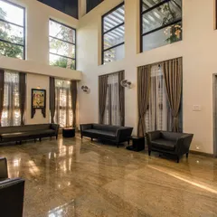 The double-height living room in the Eco Terre residence creates a sense of spaciousness and volume. Large windows ensure the area is filled with natural light throughout the day.