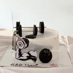 For the gym sharks! This fitness-themed cake is perfect for a gym lover, complete with an edible barbell, weights, and a bicep illustration.