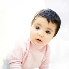 A simple, beautiful portrait taken at home. The soft, bright background highlights her sweet face and curious gaze. This is the beauty of a lifestyle session.