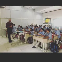 This is a typical classroom session where students are actively engaged in a discussion. I encourage a collaborative environment where children learn from me and from each other, building both their language skills and their ability to work in a team.