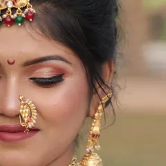 A detailed close-up of a Maharashtrian bridal makeup look. This shot highlights the flawless HD base, the beautifully blended eyeshadow, winged eyeliner, and the iconic crescent moon bindi, essential elements of the Peshwai style.