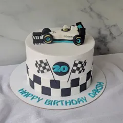 Turning 20 on full throttle! This Formula 1 themed cake features a checkered flag pattern and a handcrafted Mercedes F1 car on top.
