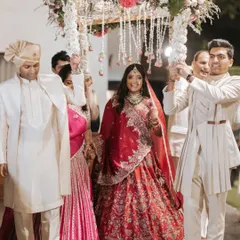 A bride's beautiful entrance under a floral 'phoolon ki chadar'. This simple yet elegant detail, adorned with hanging flowers, adds a touch of tradition and romance to her walk down the aisle.