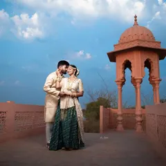 An intimate portrait on the palace terrace against a dramatic blue sky. This photo captures a quiet moment of connection between the couple, with the historic architecture adding to the romantic atmosphere.