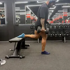 Performing Bulgarian split squats with dumbbells. This is a fantastic unilateral exercise for building quadriceps and glute strength while also improving balance.