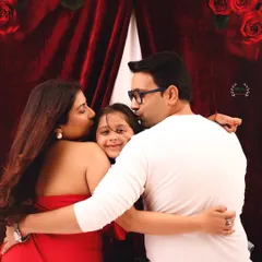 A moment of pure family love. Both parents kiss their daughter's cheeks in this heartwarming photo from their Valentine's family and maternity session.