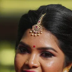 A detailed shot of the bride's maang tikka and hairstyle. The hair is styled in a clean updo to beautifully showcase the traditional jewellery piece.