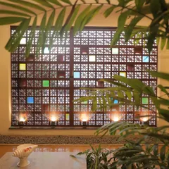 A closer look at the `jaali` screen, framed by indoor plants. This feature is central to the home's design, connecting the interior to traditional South Indian architectural elements.