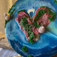 Another view of a heart-shaped island, crafted with textured rock, moss, and real shells, all encased in shimmering resin. Each piece is a miniature world, unique and made by hand.