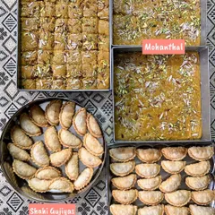 A festive spread of traditional Indian sweets, featuring trays of rich Mohanthal and perfectly shaped Shahi Gujiyas, made especially for Raksha Bandhan.
