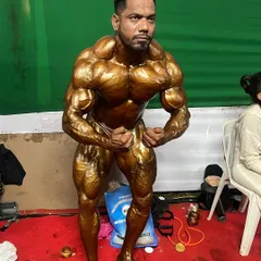 Holding the most muscular pose, focusing on tensing every muscle group to display the complete, conditioned package.