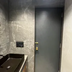 A look at the powder room from the Sanpada project. We used dramatic grey marble-finish tiles on the walls and a sleek black vessel sink to create a bold and sophisticated statement.