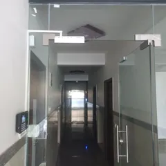 This view showcases the complete access control solution for a glass entryway. The system includes a biometric reader for verification and a secure locking mechanism at the top of the door.