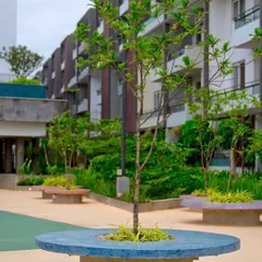 Another view of the landscaped community area at 'Poetree', showing the integration of greenery and seating. The design provides clean, efficient living spaces with plenty of outdoor green areas.