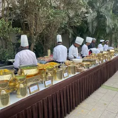 A beautiful high-tea buffet setup featuring classic Gujarati delicacies at Novotel Imagica. Our chefs are lined up, ready to serve guests a variety of fresh, hot snacks and dishes.