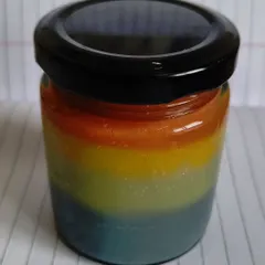 The finished Unicorn Body Butter, a custom creation. The rainbow layers are colored with clays and turmeric, and it's packed with skin-loving ingredients.