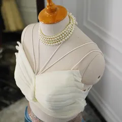 A close-up of the intricately pleated butterfly crop top, designed to create a unique and sculptural shape.