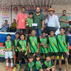 Celebrating every player's effort is key. Here, a young football team proudly displays their medals and trophy at a local tournament I organized, highlighting my focus on creating rewarding experiences for kids.