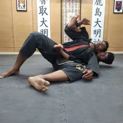 This image shows one of our young students practicing a guard position. We teach them how to use their legs to defend and control, a core concept in Brazilian Jiu-Jitsu.