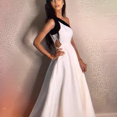 A sleek and modern option. This white scuba gown features a one-shoulder design with a contrasting black sequin detail for a chic and high-fashion look.