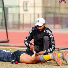 A coach tending to a player's injury on the sidelines. We take care of our own.