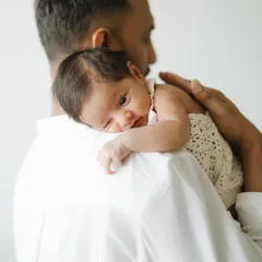 A father's shoulder is one of the safest places in the world. This tender moment from an at-home newborn session captures the quiet bond between a dad and his brand new baby.