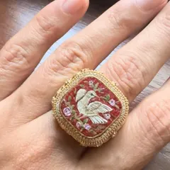A micromosaic ring featuring two doves, symbolizing love and partnership. Handcrafted in 18k gold with a detailed filigree band, this piece is a perfect heirloom to signify a special connection.