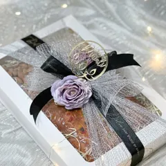 My Diwali box hamper is an elegant and simple gifting option. This beautifully wrapped box contains a large 500-gram tea cake along with jars of salted almonds and cashews. The lavender and black ribbon gives it a sophisticated touch.