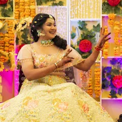 A joyful candid of the bride at her Haldi. She's wearing beautiful floral jewelry, and her makeup is fresh and minimal to complement the natural theme.