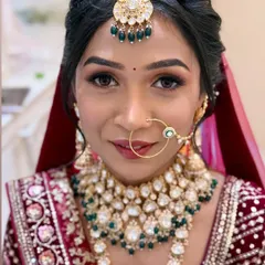 A close-up portrait showcasing the detailed makeup. The focus is on her bright eyes and the perfect base that enhances her skin.