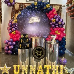 A gorgeous galaxy theme for Unnathi's 7th birthday, with a sparkling backdrop and a deep purple and pink balloon arch.