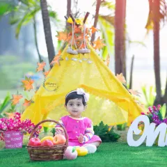 Celebrating year one with a sunny teepee setup on the beach. I provide props like this 'One' sign to make your baby's first birthday photoshoot extra special.