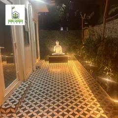 The same backyard, showing how the space flows from the house to the serene, spotlit Buddha statue at the far end. A perfect party venue.