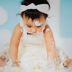 A close up of the happy mess. Capturing these sensory details, like fingers covered in frosting, is what makes a cake smash session so special and memorable.