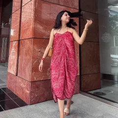 A client looking happy and carefree in her custom pleated pink asymmetric dress. This shot captures the movement of the fabric and the modern, stylish cut of this unique piece.