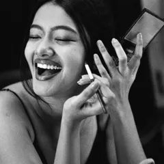 A moment of levity amidst the intense focus. This candid laugh shows the joy and humanity behind the craft of acting.