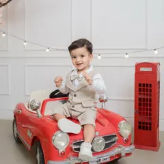 All suited up and ready to roll for his first birthday! This little gentleman looks dapper sitting on a vintage red toy car, part of our fun milestone session props.