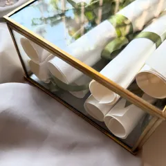 A close-up of the glass keepsake box filled with handwritten vow scrolls. This is a beautiful way to store and display the most important words you'll ever exchange.