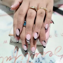 A sleek and graphic look, these long almond nails feature a deep black French tip with a sharp, modern curve.